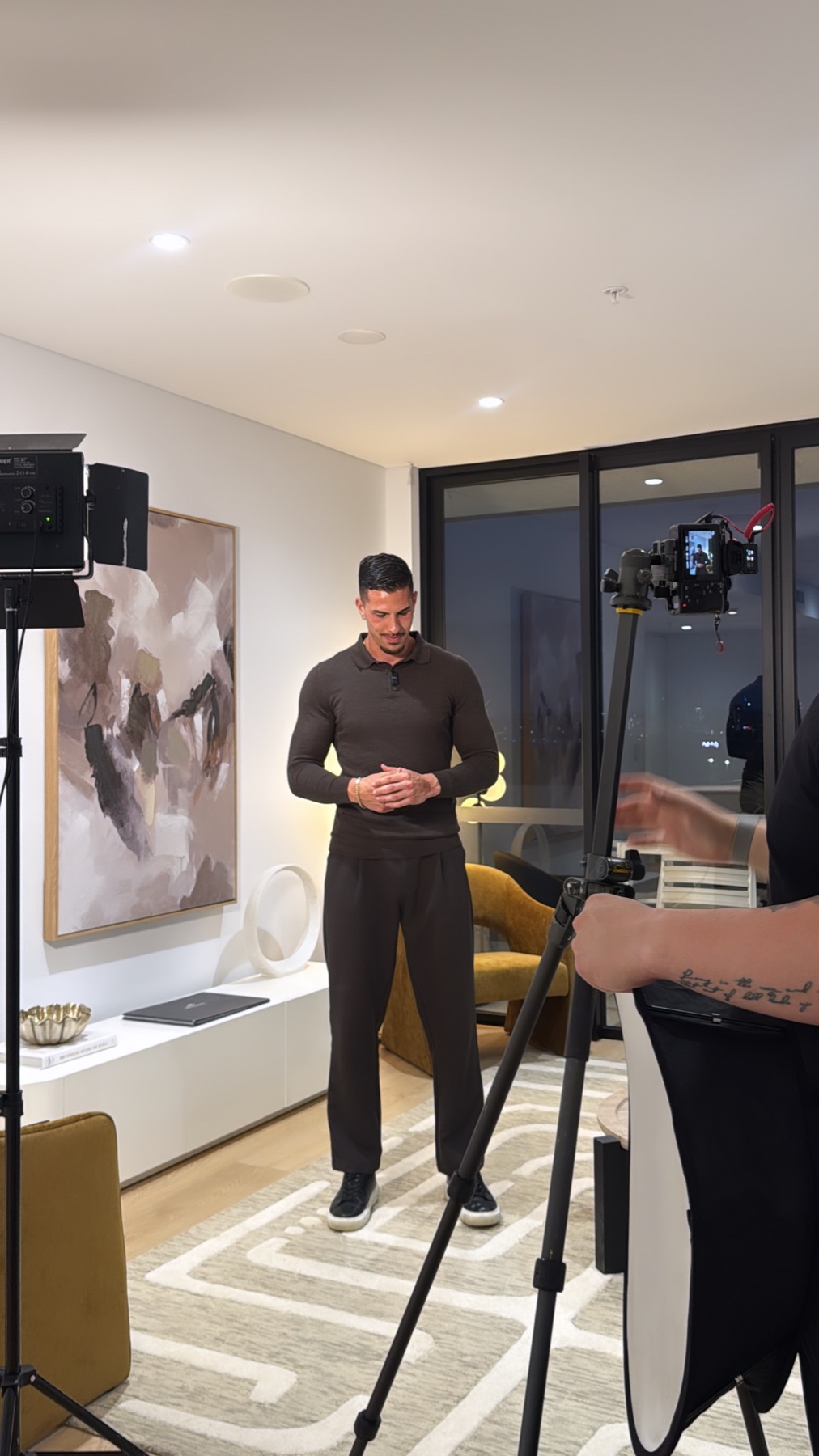 A behind-the-scenes production set with a presenter, cameras and studio lighting